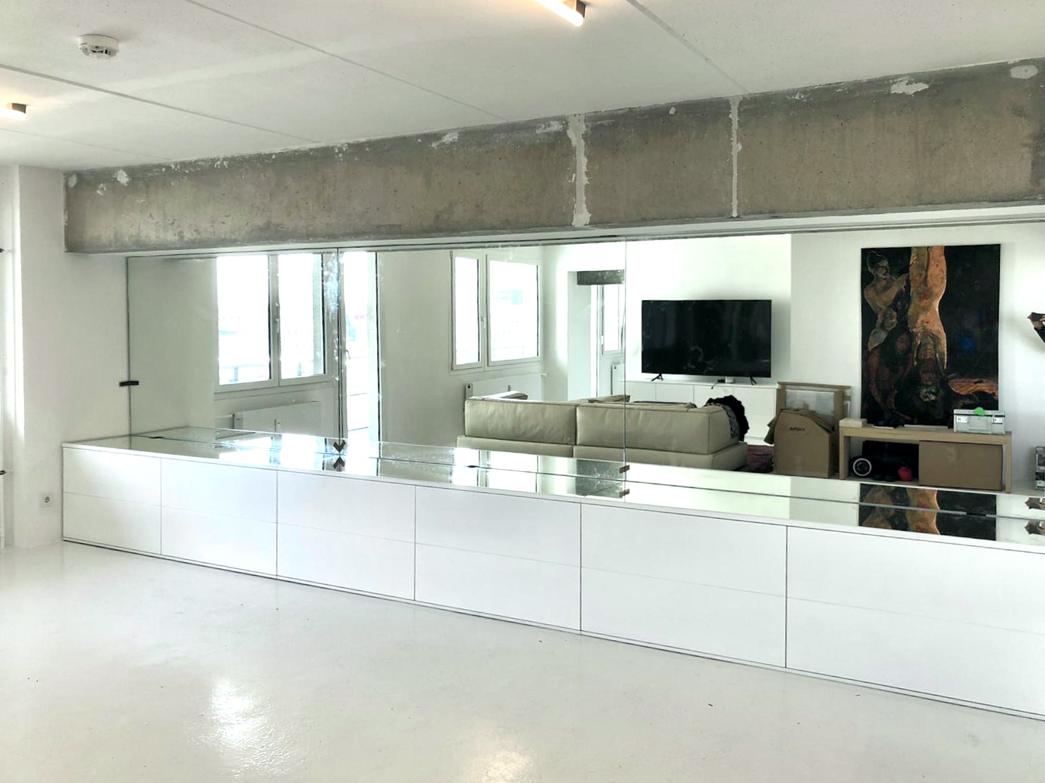 Open Forum Living 44 — open plan living area, mirrored wall panel, exposed WBS 70 concrete beam, white resin floor